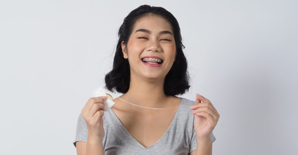 Dental brace teen girl smiling looking on a camera. white teeth with blue braces. Dental care. Asian