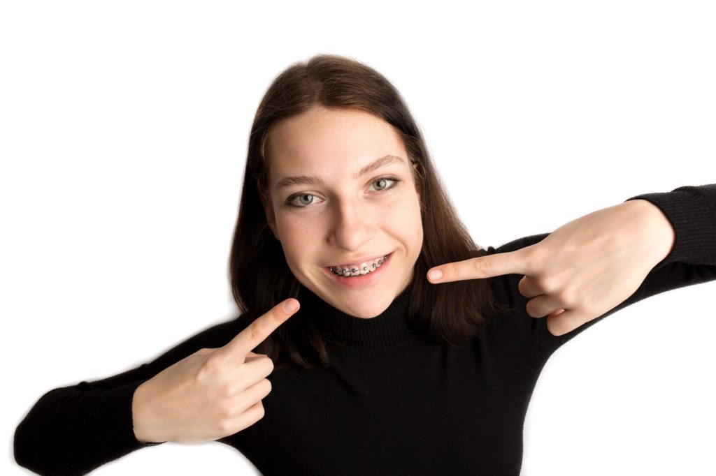 Orthodontic treatment. Dental care concept. Smiling teenage girl with braces.